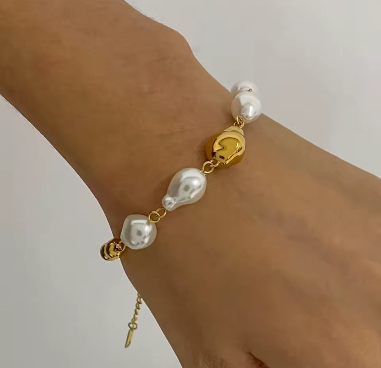Pulsera dorada con perlas